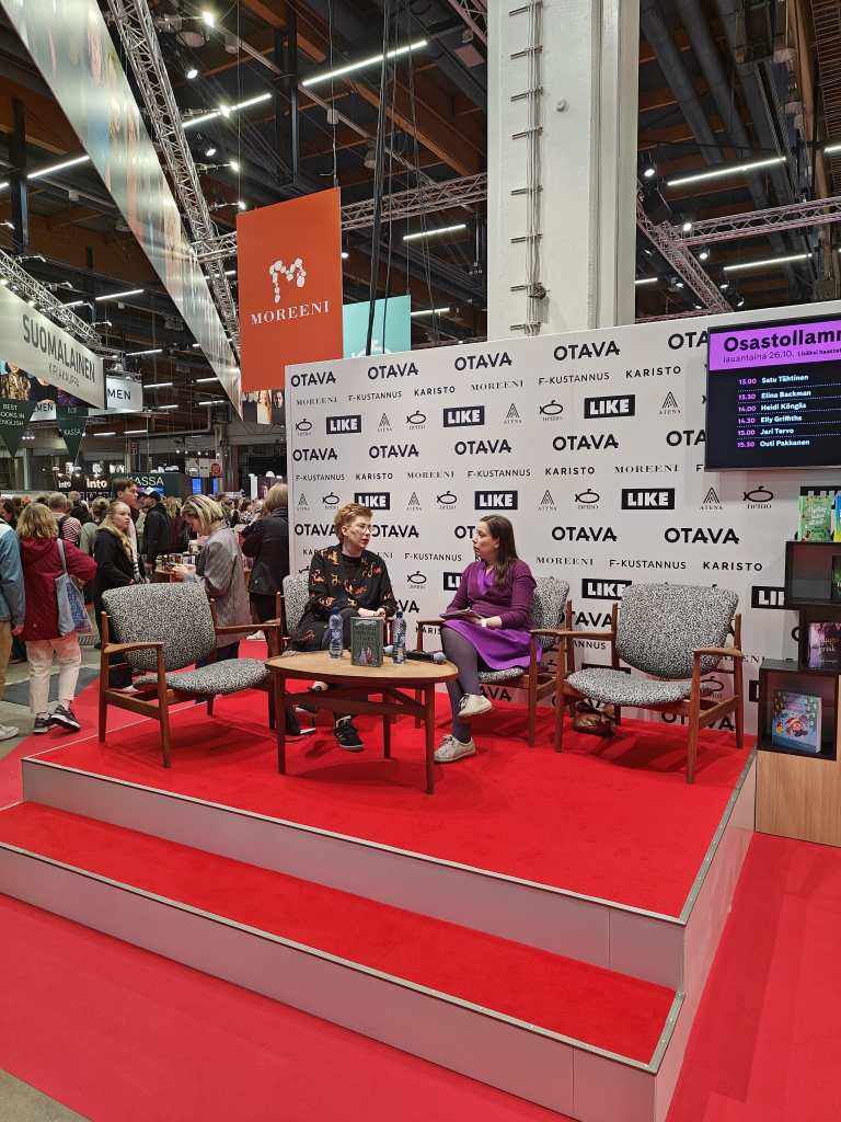 Satu haastateltavana Helsingin kirjamessuilla. Hanna Soisalo haastattelee.